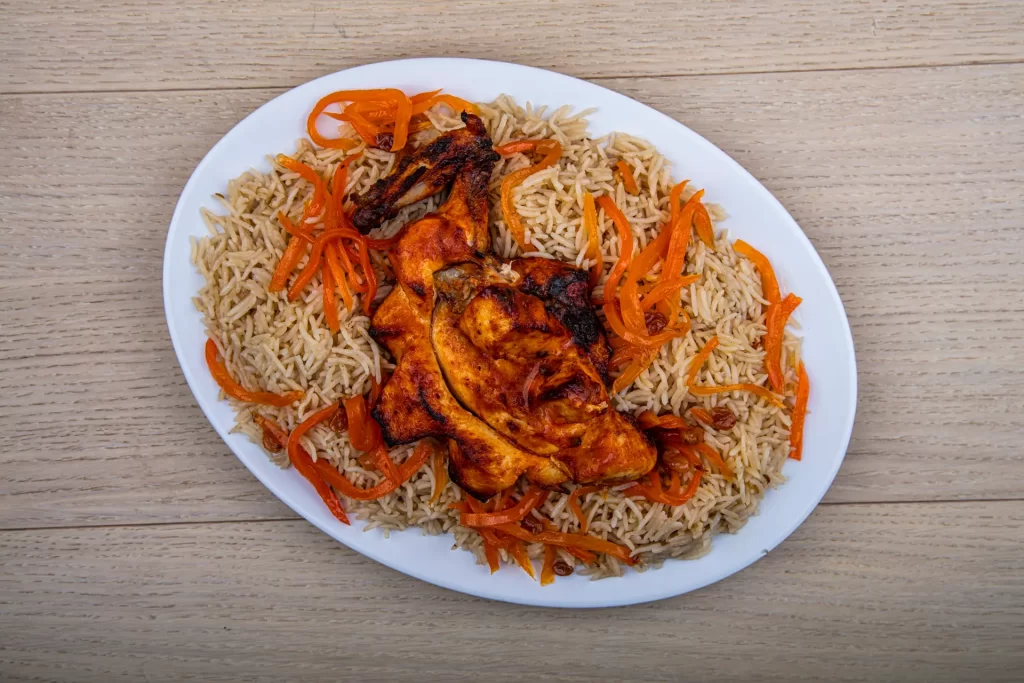 Plate of chicken and rice on wooden table