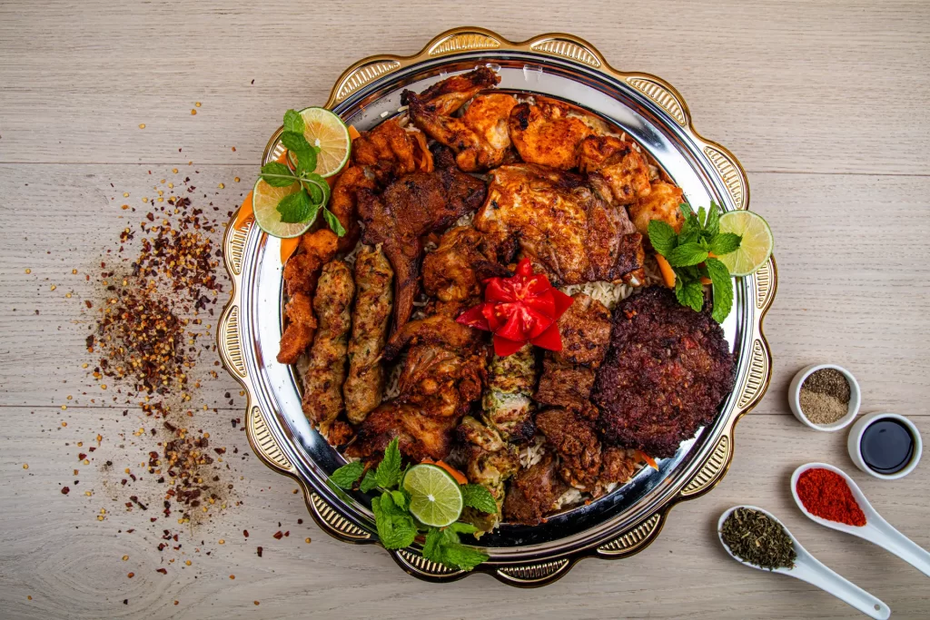 Half platter of Pakistani food with chicken tikka masala, lamb curry, rice, and naan bread.